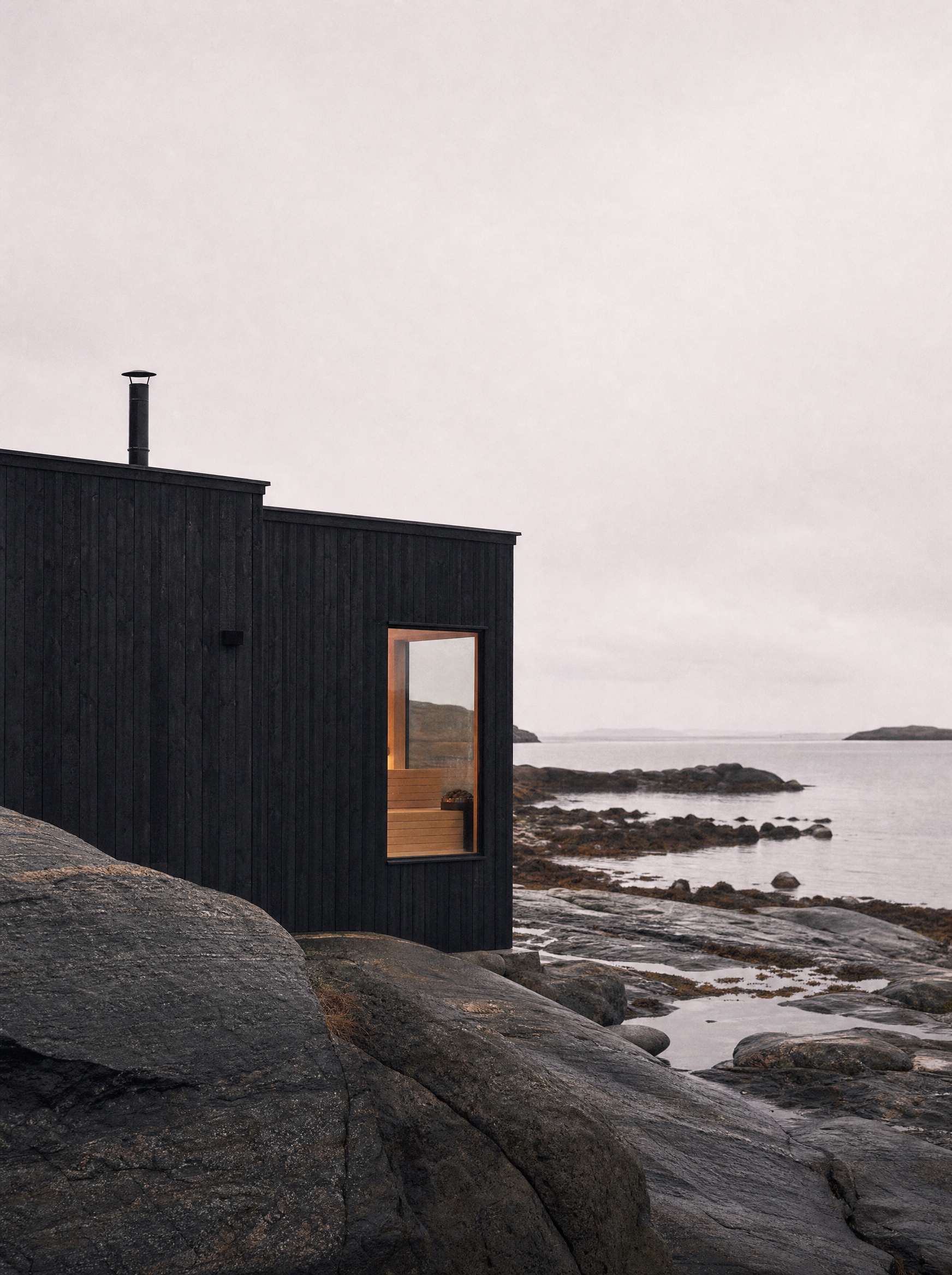 Timber sauna on a rocky Norwegian shoreline